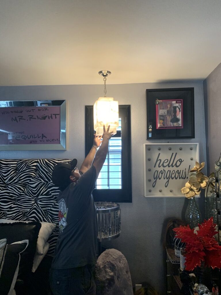 An electrician installing a new ceiling light fixture for Steve Cavenee Electric in Orange, CA.