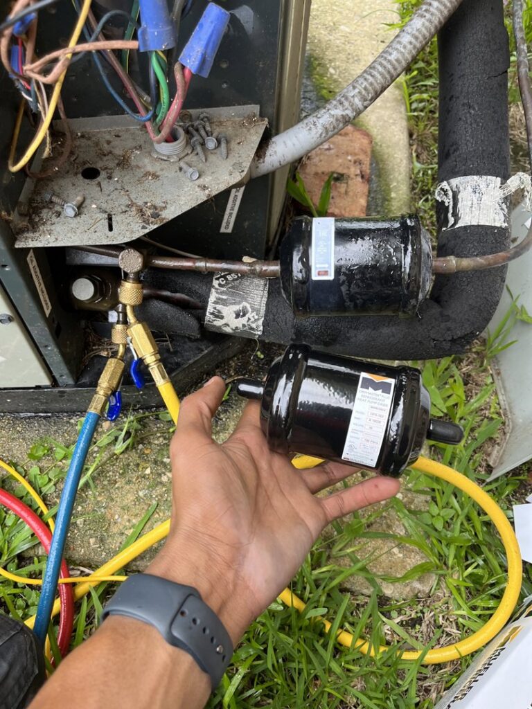 A technician installing a new refrigerant filter drier on an outdoor HVAC unit during service by Keith HVAC & Electrical Enterprises LLC in New Orleans, LA.