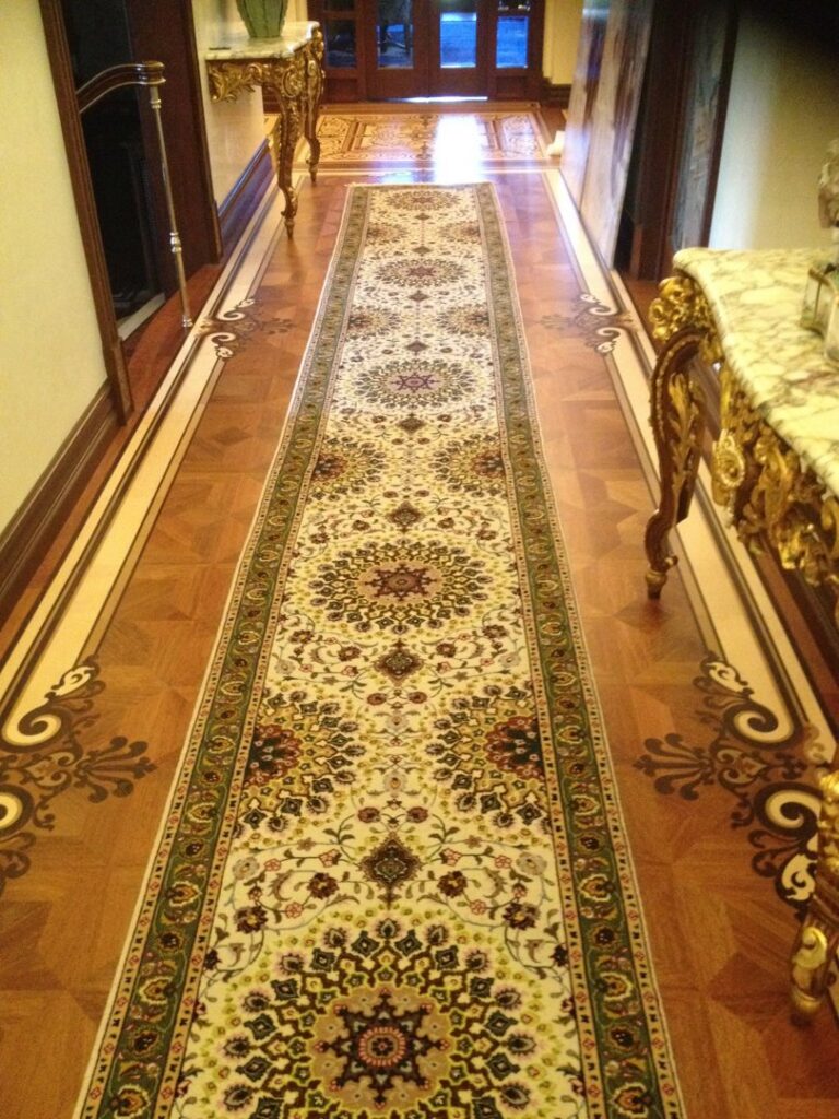 Two professionals expertly installing a patterned carpet runner on a staircase for a client of Ko-Z-Craft in Los Angeles, CA.