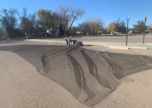 Technicians installing a large wildlife exclusion net in a parking lot for Horizon Pest Control in Carlsbad, NM.