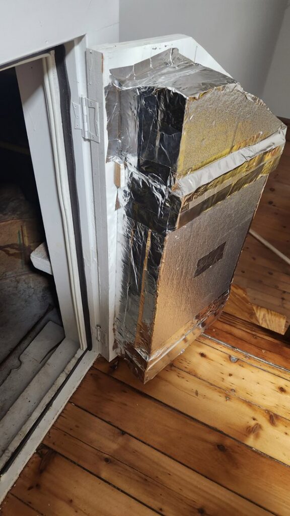 An insulated attic access door, improving home energy efficiency by HomeWorks Energy in Medford, MA.
