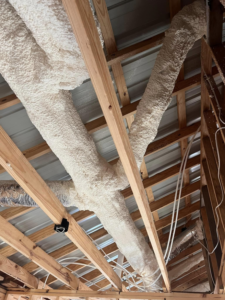 Insulated HVAC ducts installed in a ceiling with exposed wooden beams by Smartcool Inc. in Pine Bluff, AR.