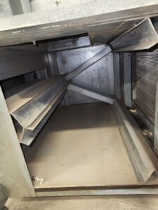 Dirty HVAC unit or large ductwork interior, showing accumulated dust and debris, ready for cleaning by DUCTZ of Siouxland in Vermillion, SD.