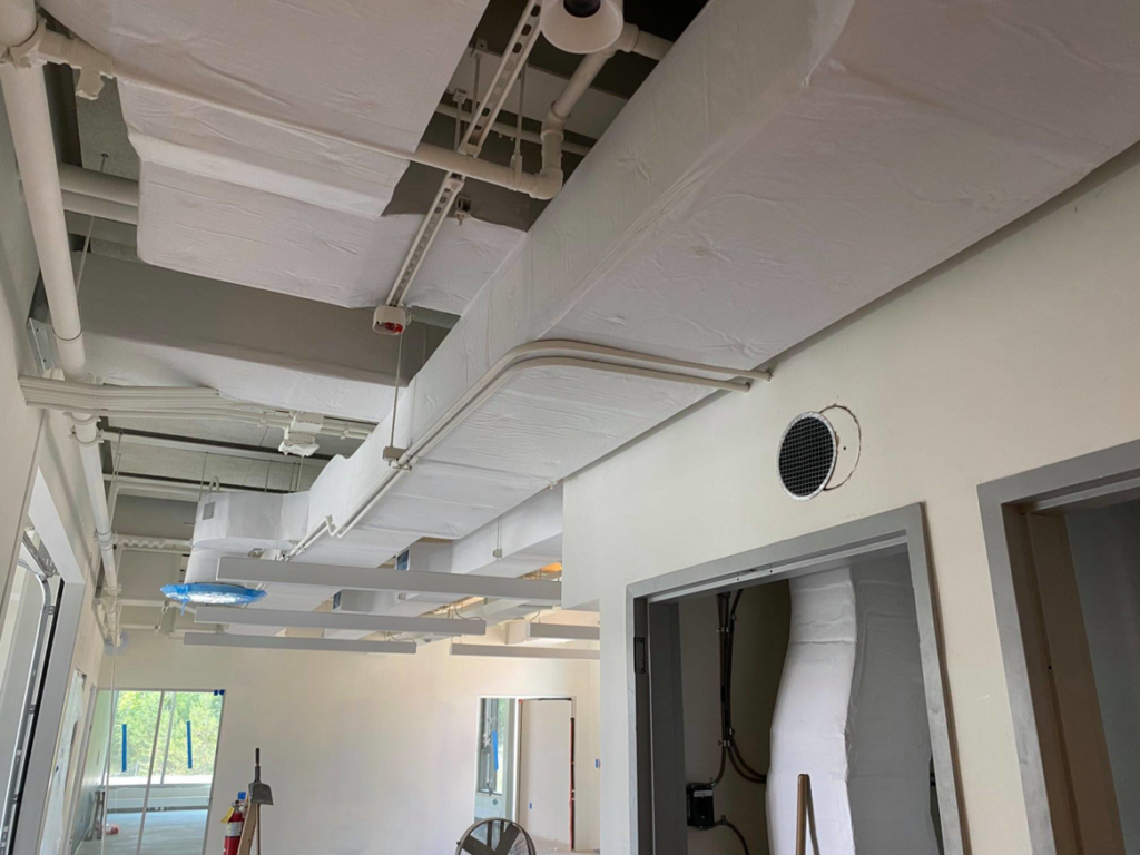 Interior view of exposed and insulated HVAC ductwork and piping installed by North Country Mechanical Insulators in South Burlington, VT.