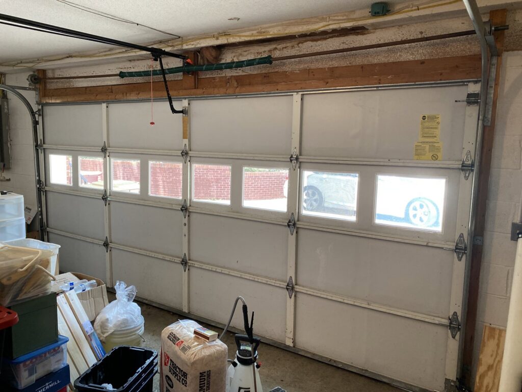 Interior view of a garage door with windows, showing tracks and opener system by Precision Door Service of Huntsville, AL.