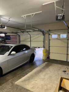 Interior view of a garage with an open door, showing tracks and opener mechanism by Precision Garage Door Service of Mobile in Mobile, AL.