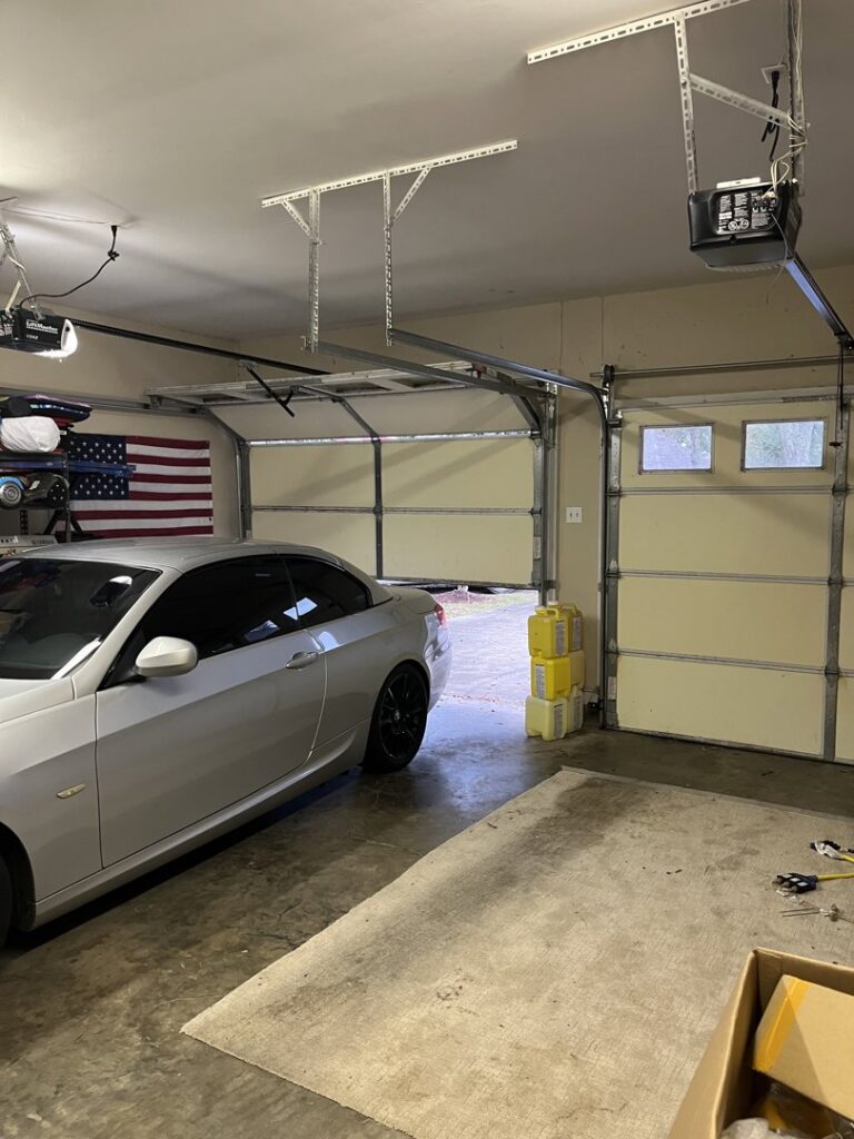 Interior view of a garage with an open door, showing tracks and opener mechanism by Precision Garage Door Service of Mobile in Mobile, AL.