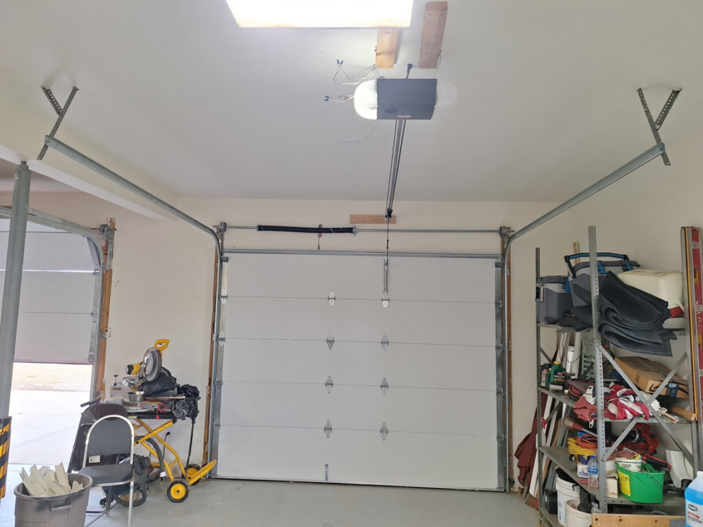 Interior view of a garage with a closed door and visible opener system by Roll-Rite Garage Doors in Denver, CO.