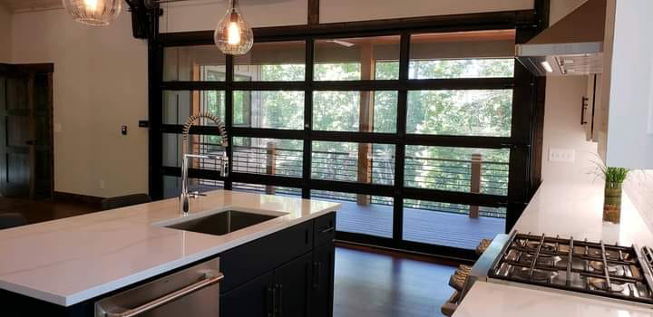 Modern kitchen with a large glass garage-style door installed by Garage Door Technologies in Minneapolis, MN