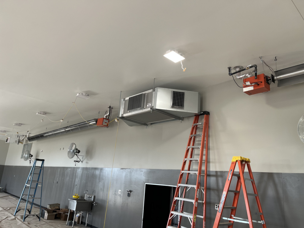 Interior HVAC ductwork and suspended heaters being installed in a commercial space by Atlas Heating and Air, LLC in Talent, OR