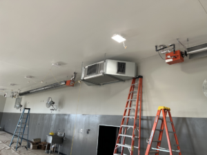 Interior HVAC ductwork and suspended heaters being installed in a commercial space by Atlas Heating and Air, LLC in Talent, OR