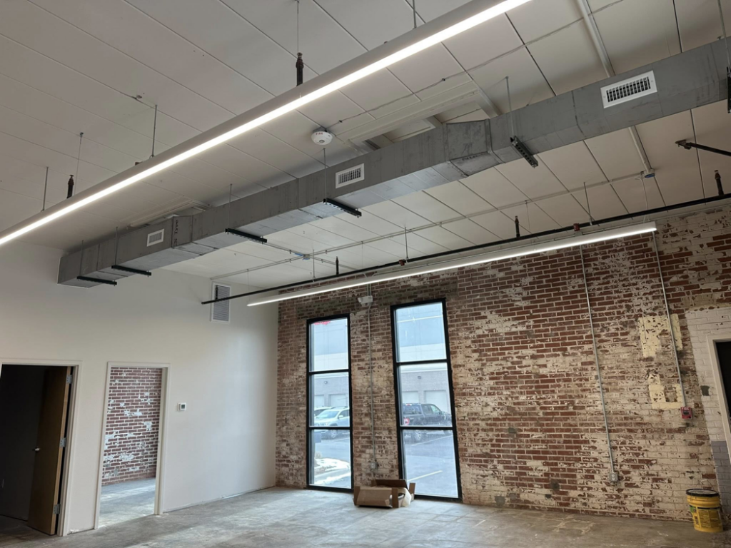 Interior lighting installation in a commercial space with exposed brick by BEC Contracting, LLC in Clover, SC.