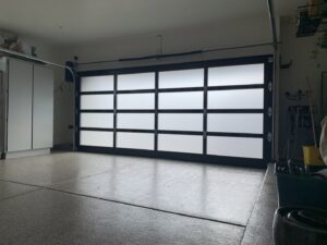 Interior view of a garage with a modern frosted glass panel garage door installed by Blue Fox Garage Doors in Gilbert, AZ.