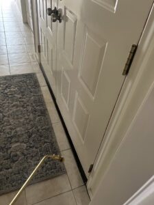 A pest control technician from Sandstorm Pest Control treating an interior door frame in Chandler, AZ.