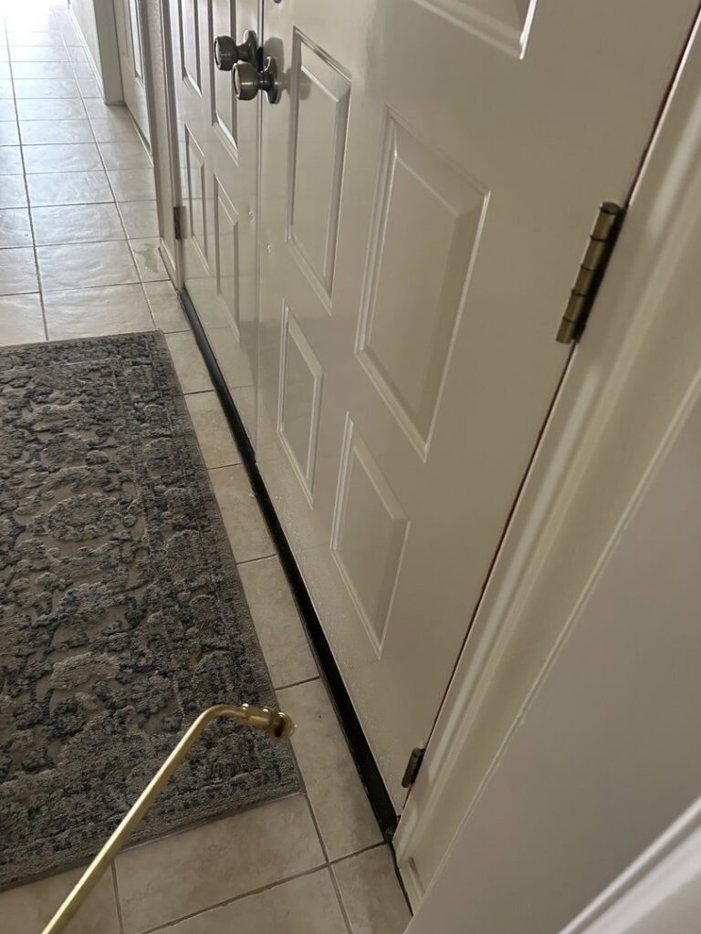 A pest control technician from Sandstorm Pest Control treating an interior door frame in Chandler, AZ.