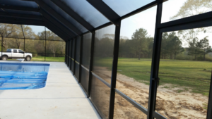 Interior view of a pool enclosure with a covered swimming pool by Backyard Paradise in Mobile, AL.