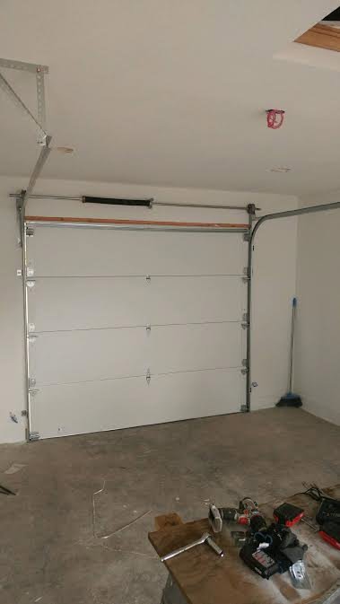 An interior view of a white paneled residential garage door installation by Xpress Doors LLC in Salem, OR