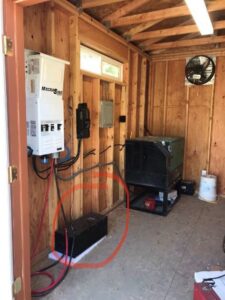 Interior view of a solar inverter and electrical panel setup in a wooden shed by J C Electric & Solar in Lewiston, ID