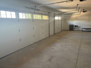 Interior view of two newly installed white garage doors by Lion Heart Garage Doors in Thornton, CO.