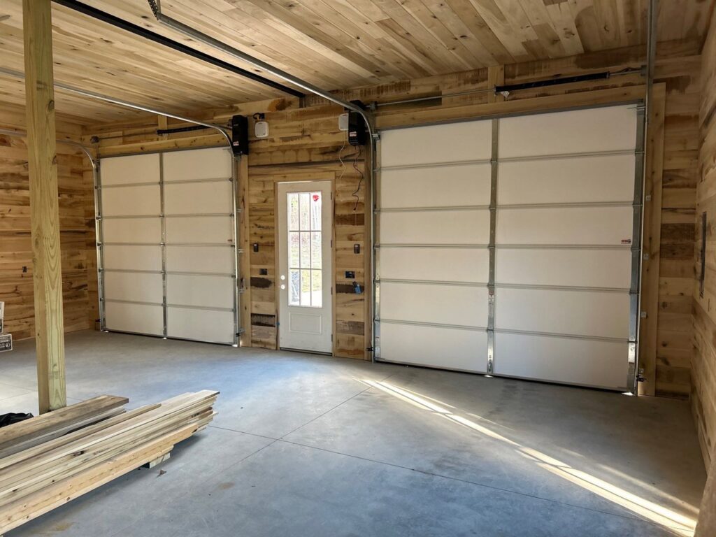 Interior view of a garage with two white residential garage doors installed by Northern Door Company in Saint Paul, MN