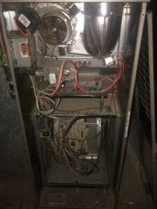 An interior view of a furnace or air handler showing wiring and components, serviced by Elements Heating & Cooling LLC in Minneapolis, MN.