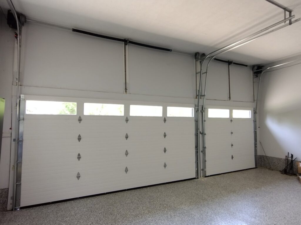 An interior view of two newly installed garage doors, showing tracks and springs, by Honest Overhead Garage Doors in Elizabethtown, KY.