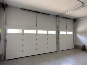 An interior view of two newly installed garage doors, showing tracks and springs, by Honest Overhead Garage Doors in Elizabethtown, KY.