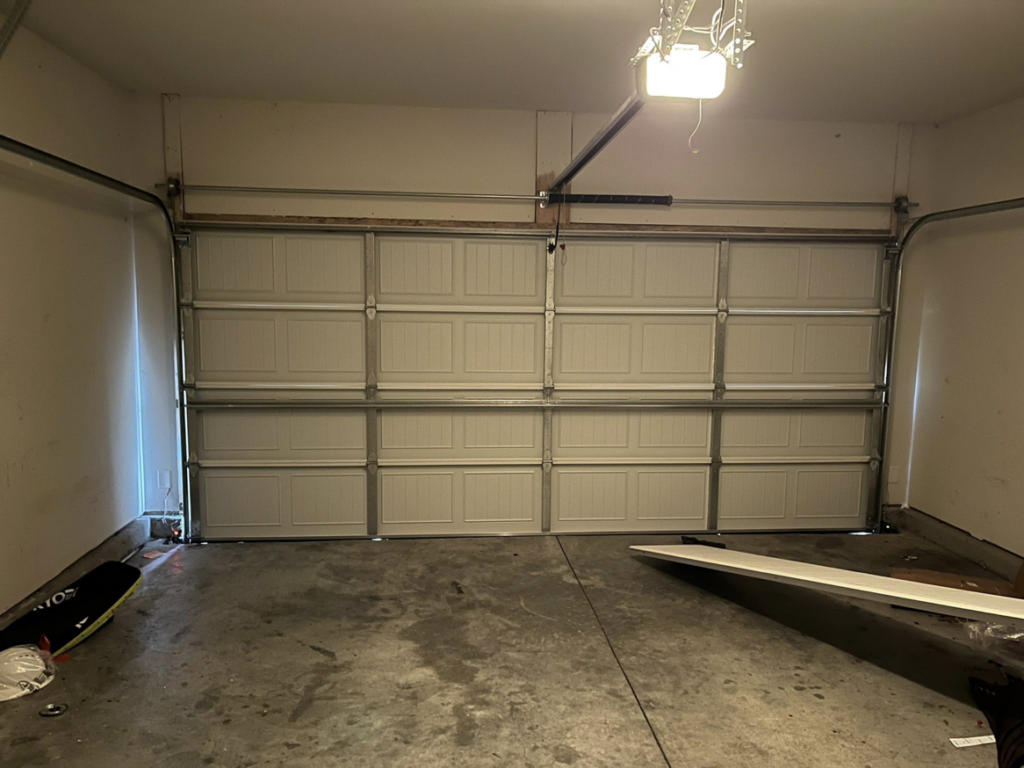 An interior view of a newly installed white garage door and opener system by J&S Garage Door Services in Franklin, TN.