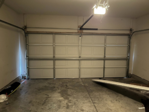 An interior view of a newly installed white garage door and opener system by J&S Garage Door Services in Franklin, TN.