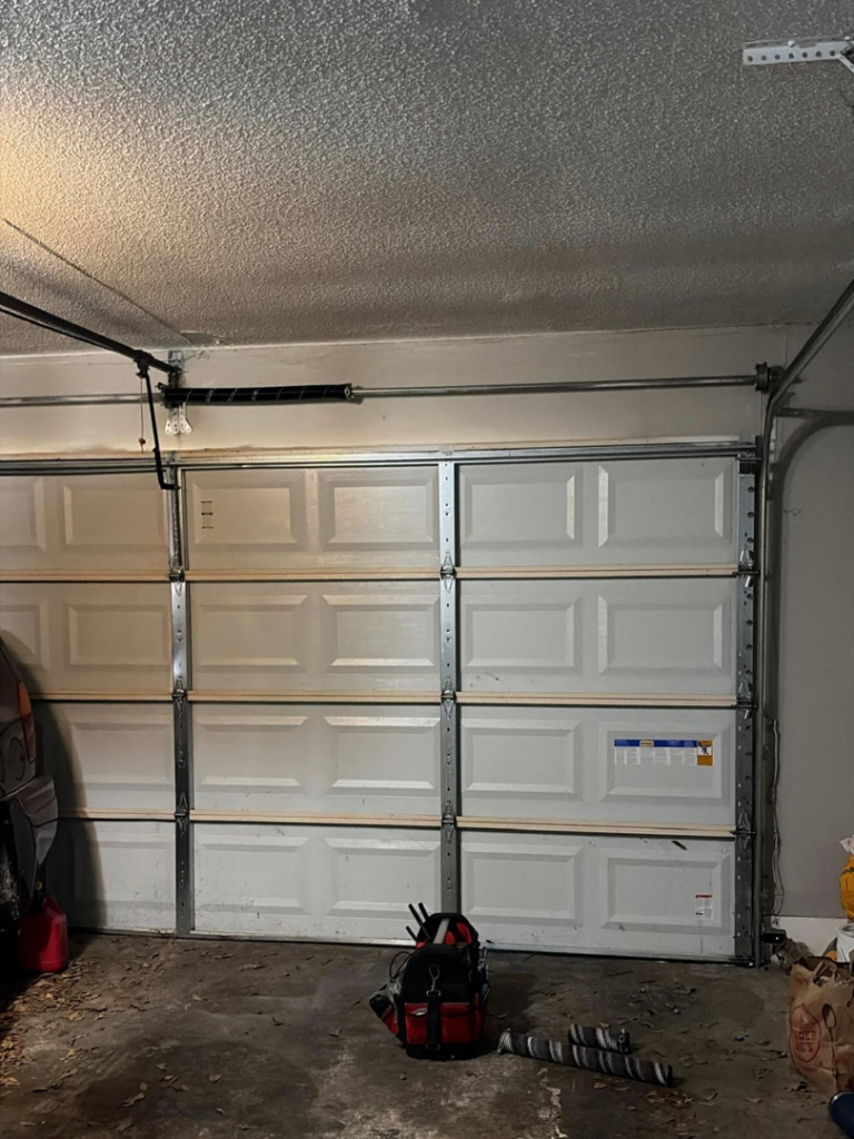 Interior view of a newly installed or serviced garage door, with tools nearby, by J&C Bravo LLC in Cordova, TN.