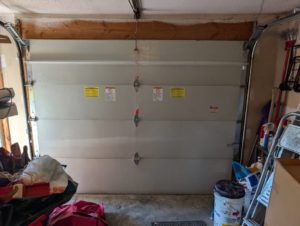 An interior view of a closed garage door, showing its panels and warning labels, by Garage Doors & Remodeling LLC in Blue Springs, MO