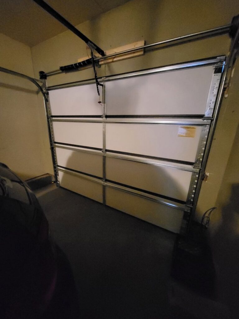 Interior view of a newly installed white panel garage door, showcasing work by Mountain Fox Garage Doors in Colorado Springs, CO.