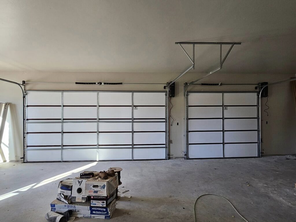 Interior view of two new garage doors installed with tracks in a garage by Total Door Solutions in Yukon, OK