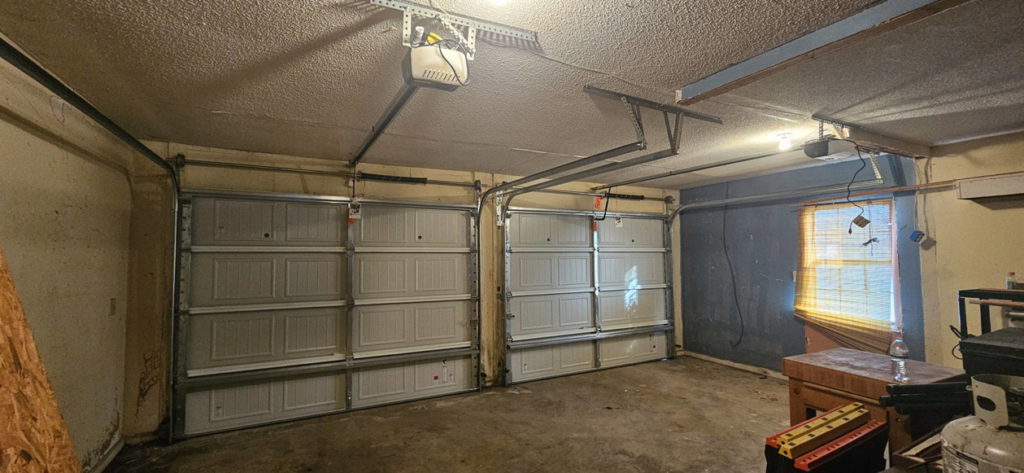 Interior view of two newly installed garage doors and openers by Skreno Services in Summerville, SC.