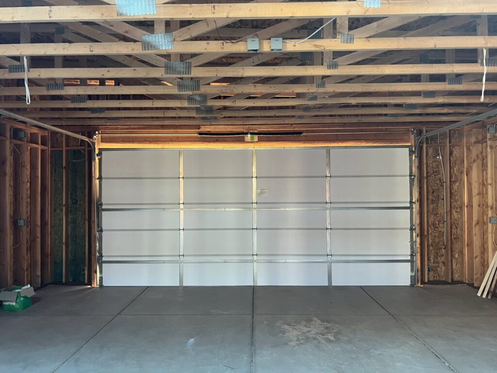 An interior view of a newly installed white garage door by Tucson Garage Door Doc in Tucson, AZ.