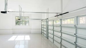 Interior view of a clean garage with an open garage door, showing the tracks and opener mechanism, by PNG Garage Doors llc in Lakewood, CO.