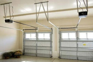An interior view of a garage showcasing two installed garage doors and their automatic openers by Above The Rest Garage Door in Colorado Springs, CO.