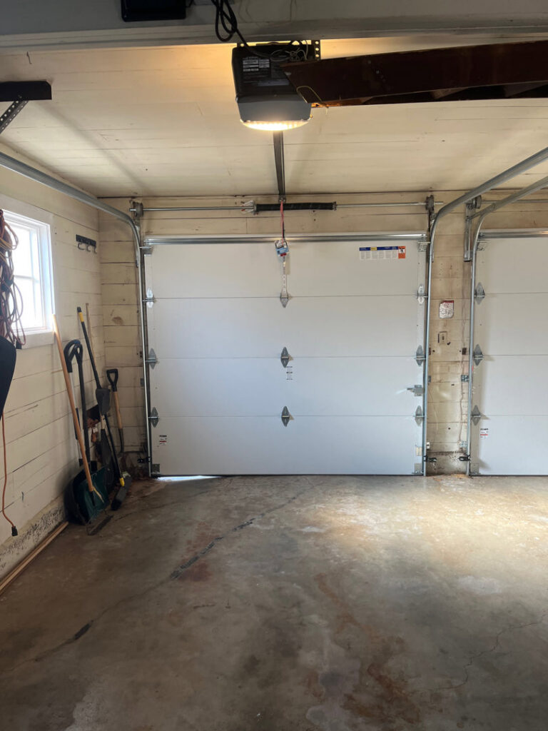 Interior view of two white garage doors and openers installed by CCM Overhead Doors in Oklahoma City, OK