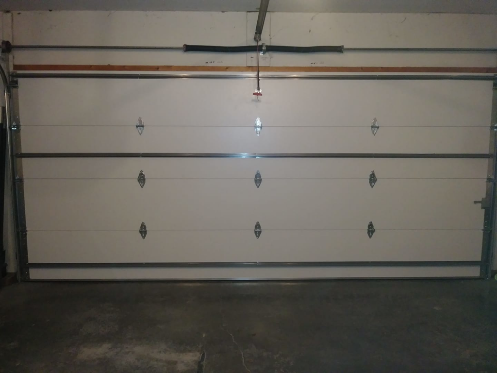 Interior view of a white garage door showing springs and tracks, installed by R&A Overhead Door in Gower, MO.