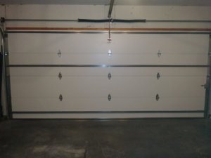 Interior view of a white garage door showing springs and tracks, installed by R&A Overhead Door in Gower, MO.