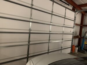 An interior view of a white sectional garage door showing the panels and tracks, installed by Affordable Overhead Garage Door in Modesto, CA