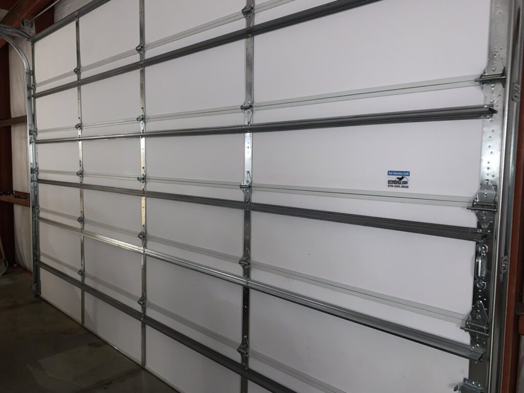 An interior view of a white sectional garage door showing the tracks and panels, installed by Affordable Overhead Garage Door in Modesto, CA