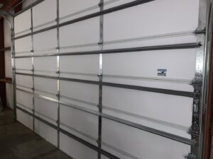 An interior view of a white sectional garage door showing the tracks and panels, installed by Affordable Overhead Garage Door in Modesto, CA