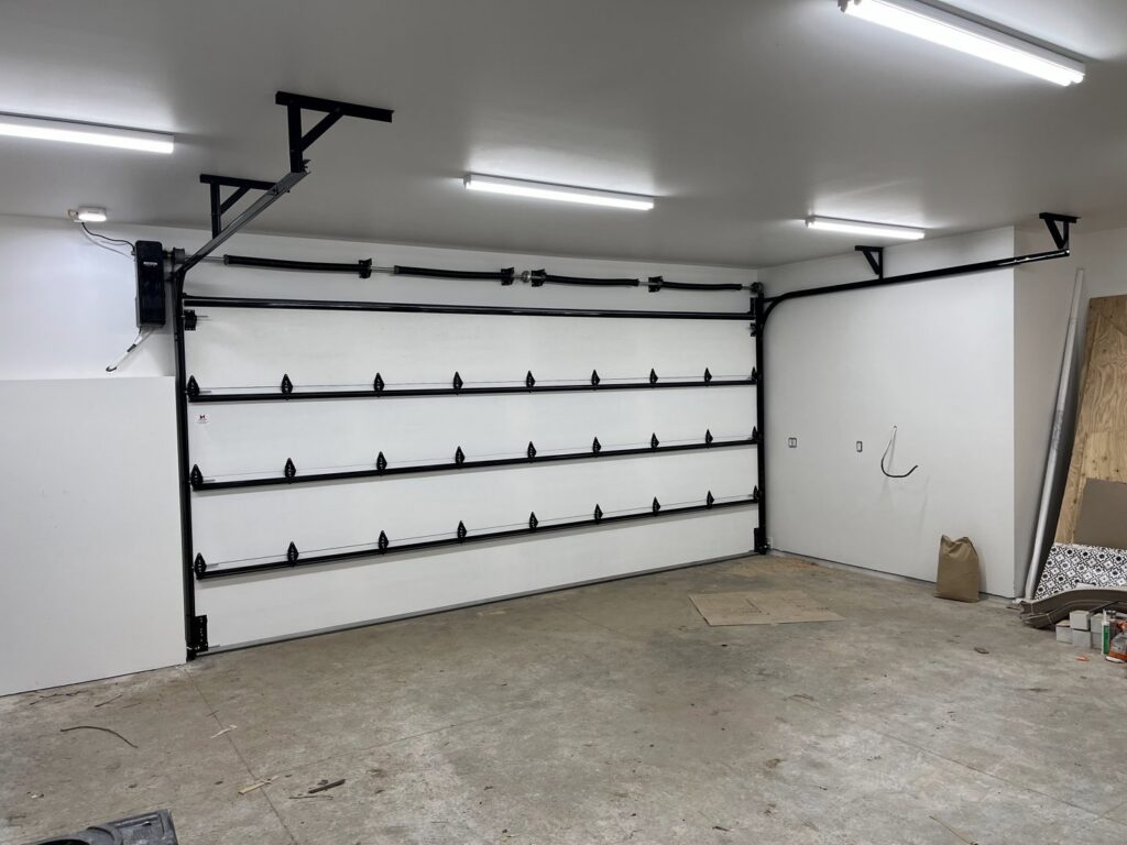 Interior view of a white garage door installation with visible tracks and springs by Remarkable Door Company in Spokane, WA.