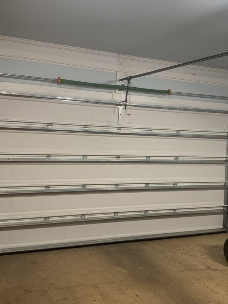 Interior view of a white garage door showing springs and tracks, serviced by Precision Garage Door Service of Mobile in Mobile, AL.