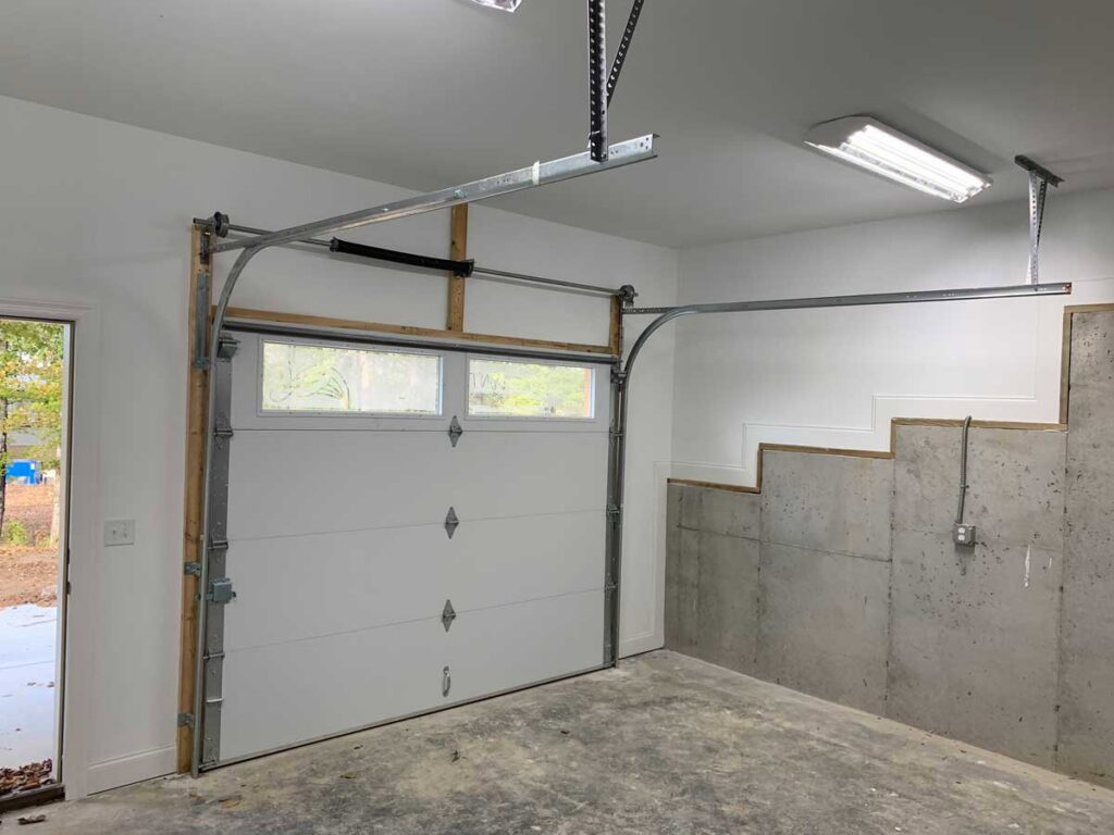 Interior view of a white sectional garage door with an opener installed by Rose Quality Garage Doors in Murfreesboro, TN