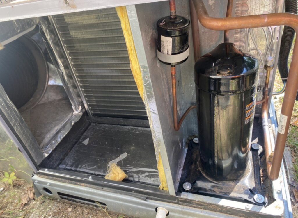 Close-up view of the internal components, including compressor and coils, of an AC unit serviced by Triune Air in Smithville, TN.