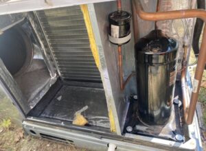 Close-up view of the internal components, including compressor and coils, of an AC unit serviced by Triune Air in Smithville, TN.