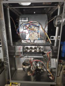 The internal components of a furnace, showing wiring and burners during a service by Sound Comfort Heating & Air Conditioning in Everett, WA.
