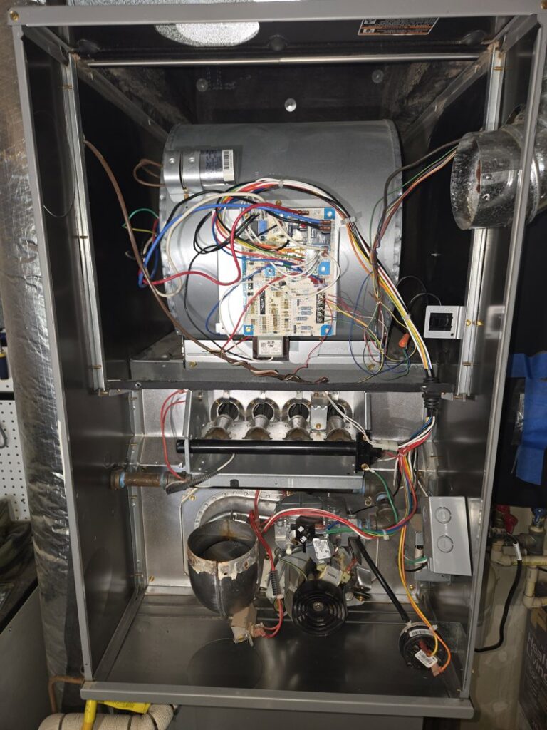 The internal components of a furnace, showing wiring and burners during a service by Sound Comfort Heating & Air Conditioning in Everett, WA.